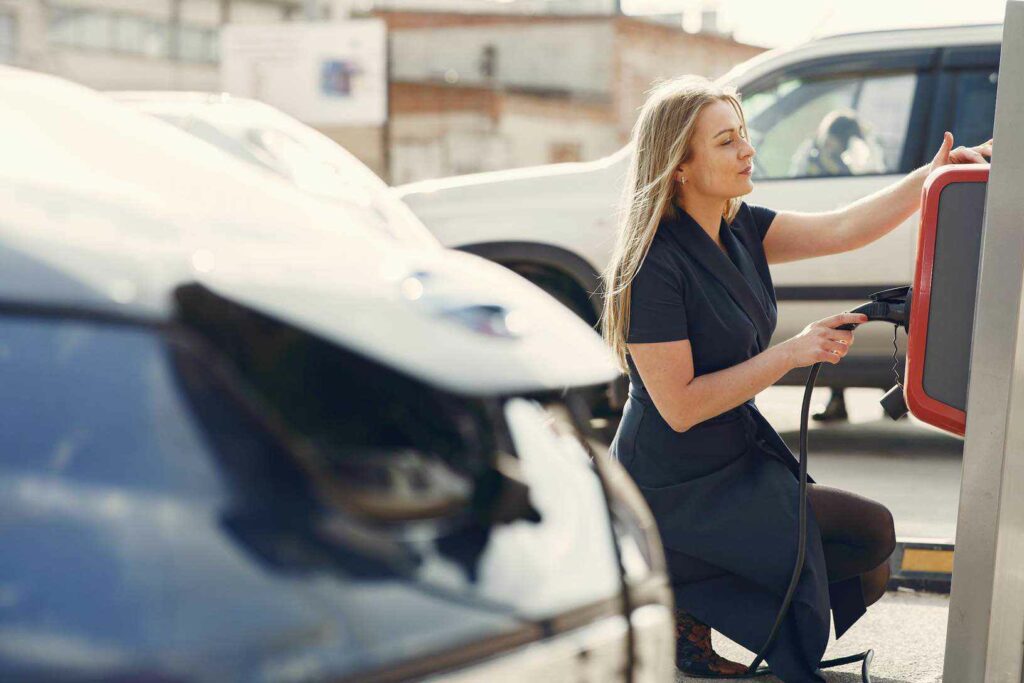 Young woman using a level 2 electric vehicle charger